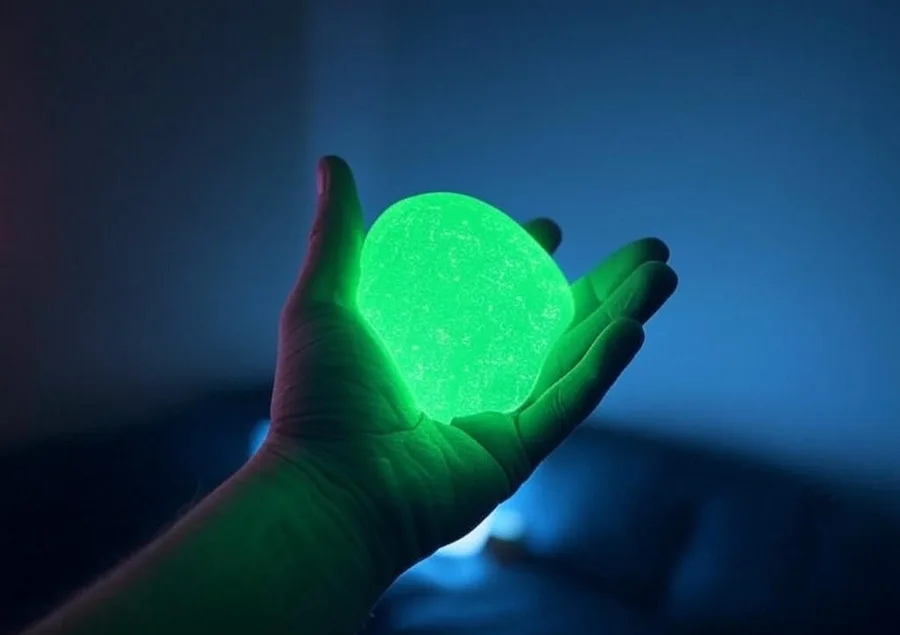 A glowing green ball held in a hand
